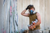 2. An Artist's Supplies : Artist, Chemis, prepares his piece with a protective mask and his cans of paint.