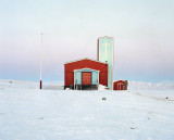 Allanngorpoq 6 : Qaanaaq’s wooden church on the outskirts of town in the midnight light of April - Over the last few decades, Greenland’s society has undergone profound evolution. Thus, as the environment shifts, its people begin to embrace Western lifestyles and modes of consumption in parallel. Supermarkets, churches and cell phones are slowly making their way into Inuit culture. For the teenagers in the major towns the memories of seal hunting trips are long gone. And when they still occur in the northernmost dwellings the traditional outfits made from animal hides mix with modern fabrics, boats are used in combination with sledges.  These radical and rapid changes raise questions about society and identity, and divide public opinion in Greenland. Its people are torn between a desire to catch up with the modern world, and a feeling that they are an ice population which, like the ice itself, is slowly melting away.  “Allanngorpoq” in Greenlandic can be translated as “being...