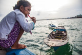 People of the Ocean : Siboto brushes her teeth in the "bathroom" at the back of the boat. There is also a family's kitchen where they make food and eat together.