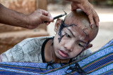 Choices They Make; Teenage Monk : Young teenage boy holding back the pain of being shaved.
