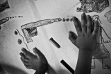 04.- Drawing violence. : In the outskirts of Caracas at a government workshop about violence and crime, a young kid draws daily scenes of violences in his community. The age of entry in crime life is dropping and there are more and more cases involving young boys of 12 or 13 years old.