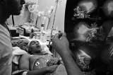09.- The last night. : Doctors examine a radiography to see the level of damage in patient Joel Pena, 18 years old, caused by a shot in the head while a fight took place in a party, Joel died a few hours later. Around 50 persons are killed every weekend in Caracas, 90% of those victims by fire arms.